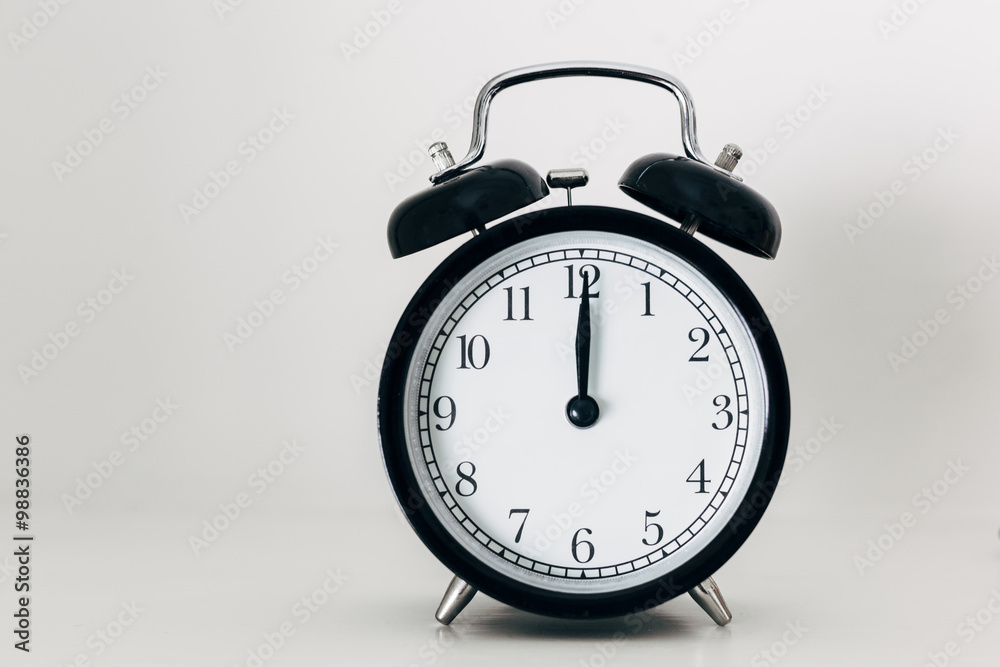 Black alarm clock showing 12 o'clock Black alarm clock showing 12 o'clock