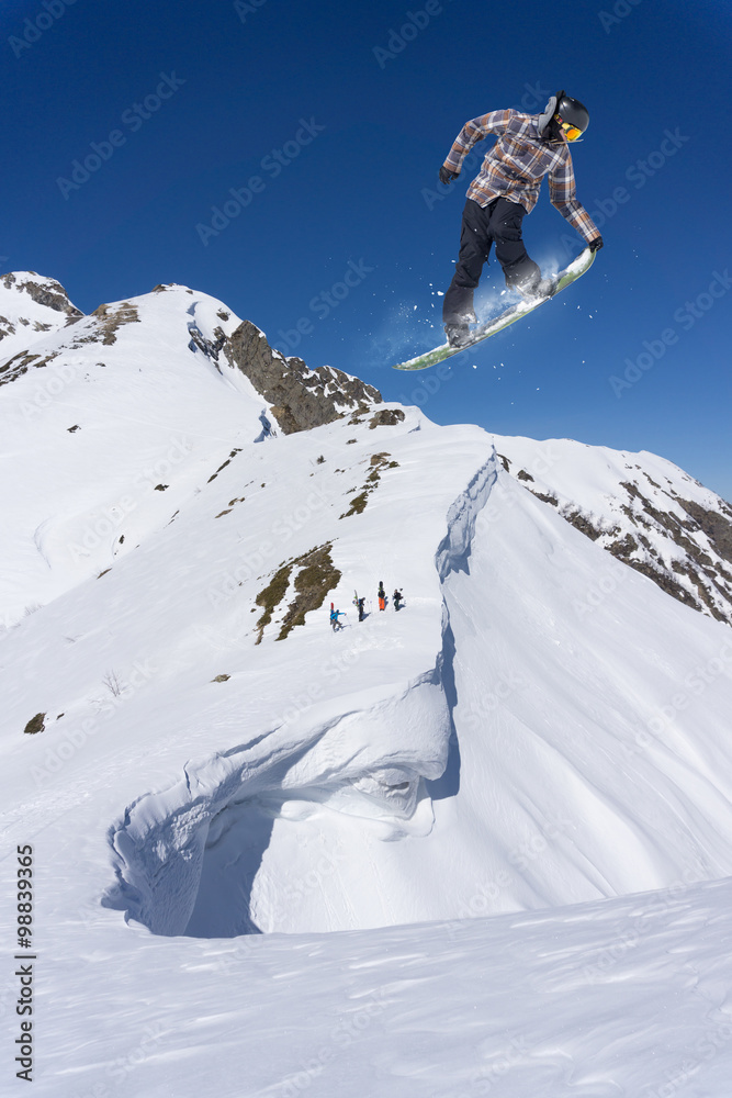 Flying snowboarder on mountains. Extreme sport.