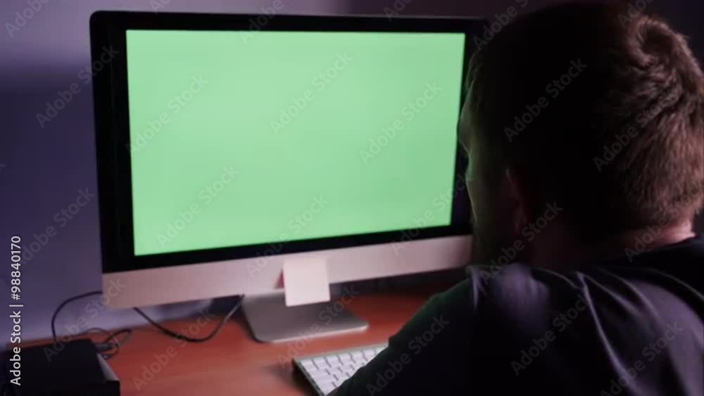 a man at the computer with green screen a man at the computer with green screen