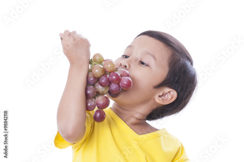 Obraz na płótnie Little boy eating grapes w salonie