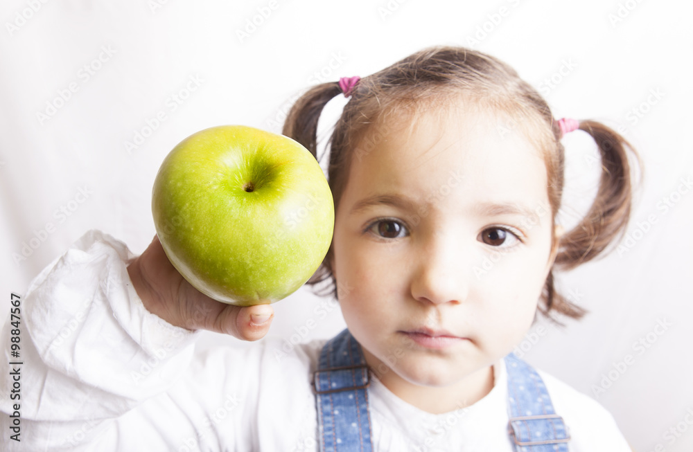 Portrait of happy girl showing a green apple Portrait of happy girl showing a green apple