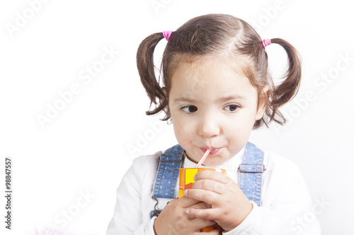 Portrait of happy girl drinking a brick fruit juice