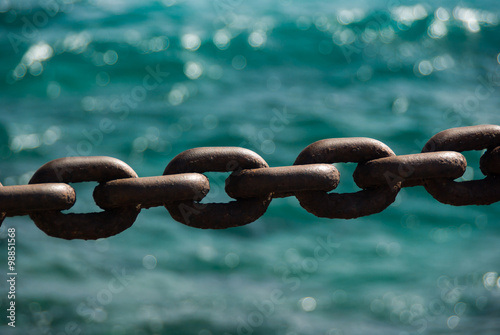 Rusty boat anchor chain in front of ocean © gerduess