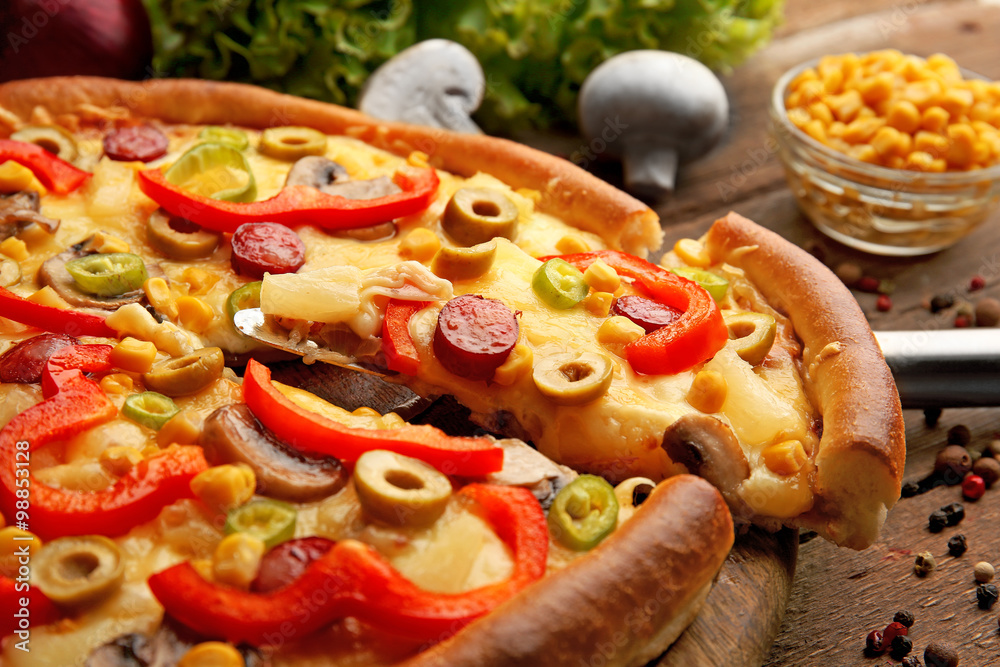 Delicious pizza with vegetables and slice on shovel, close-up Delicious pizza with vegetables and slice on shovel, close-up
