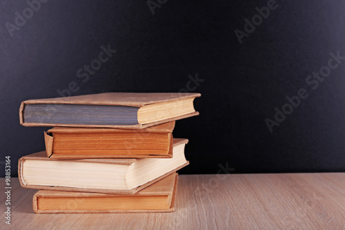 Books on a table on blackboard background