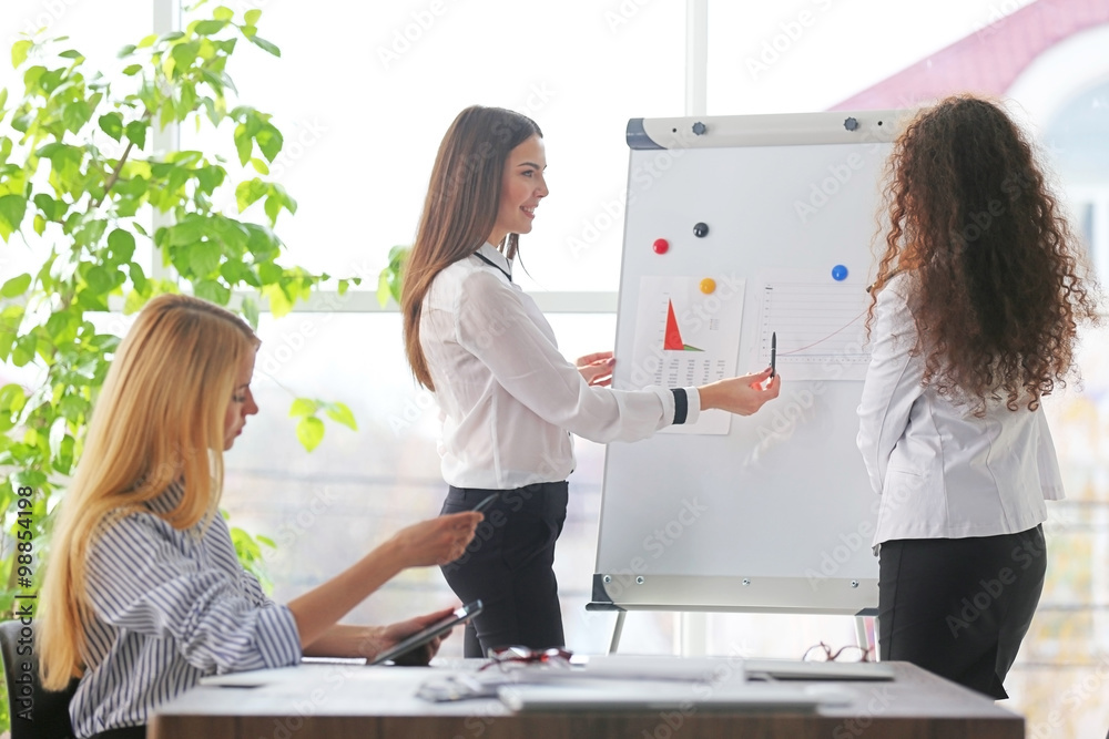 Three young businesswomen at the meeting in a conference room Three young businesswomen at the meeting in a conference room