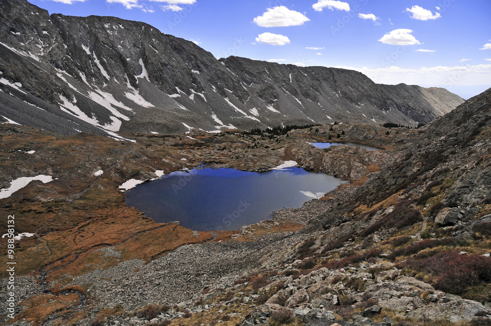 Obraz premium High altitude clear alpine lakes in the Rocky Mountains, as viewed from a mountain summit above while hiking and backpacking.