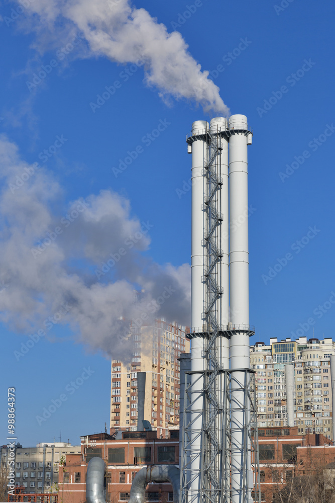 Thermal power plant with a smoke against city landscape