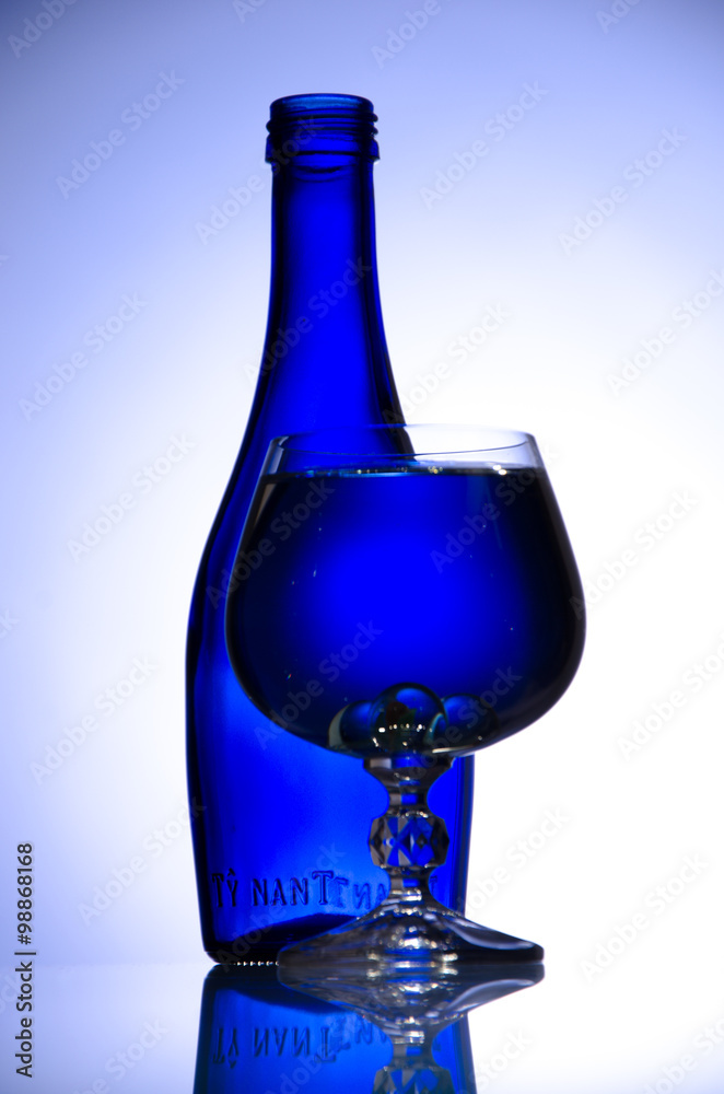 Blue bottle and wineglass on white background Blue bottle and wineglass on white background