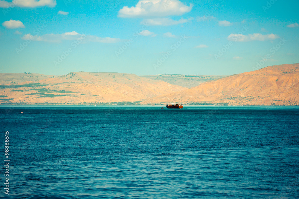 Brown wooden boat sailing in Sea of Galilee
