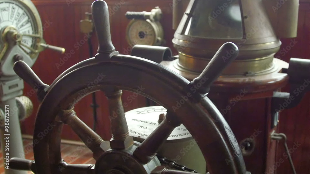 A wooden steering wheel on the captains deck. This helps in navigating in the ocean by the boatmen A wooden steering wheel on the captains deck. This helps in navigating in the ocean by the boatmen