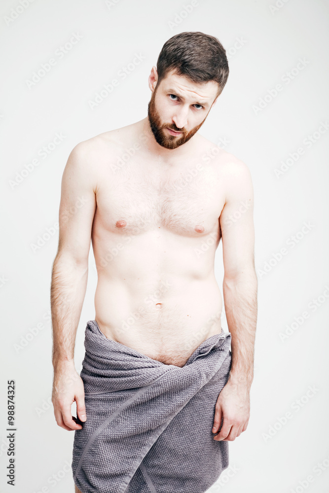Naked young man with a towel on his hips