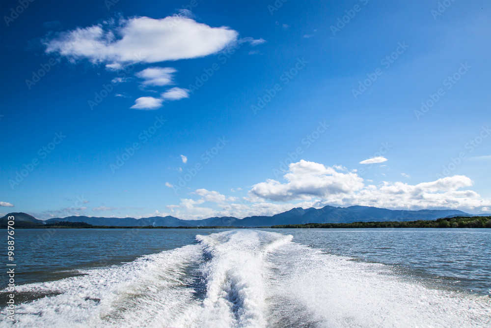 Fototapeta premium wake of a passenger ship , blue sky and clouds