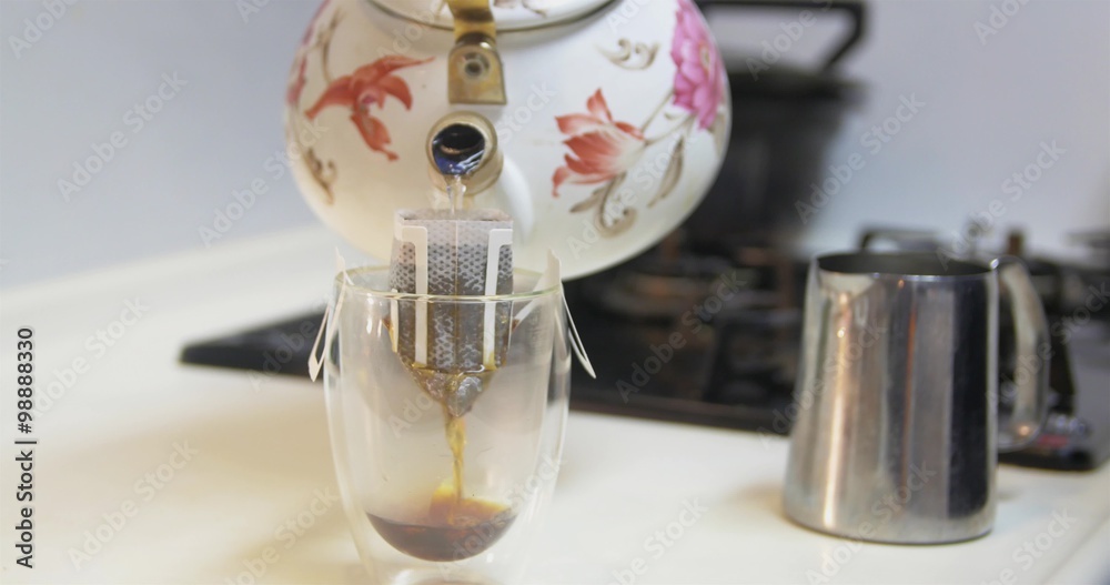 Pouring fresh hot coffee into a stylish glass cup Pouring fresh hot coffee into a stylish glass cup