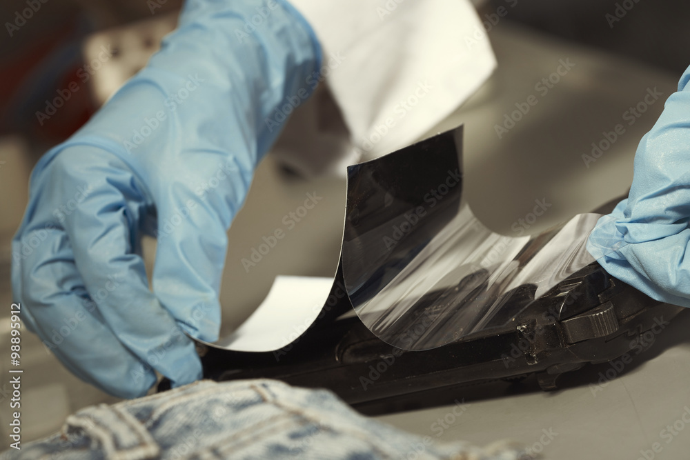 Lifting fingerprints from handgun in laboratory