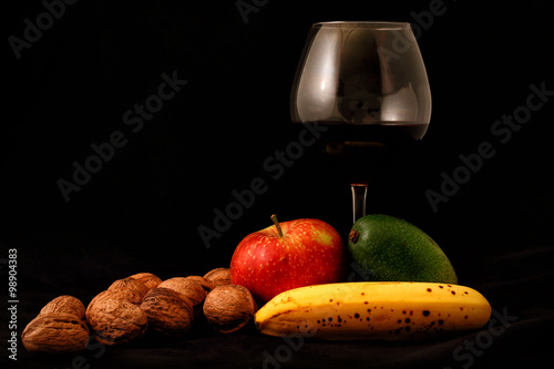 fruit mix and glass of wine on black background