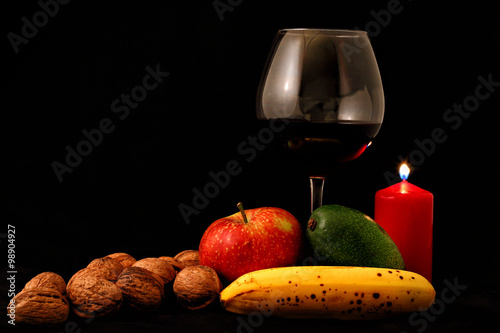 fruit mix and glass of wine on black background