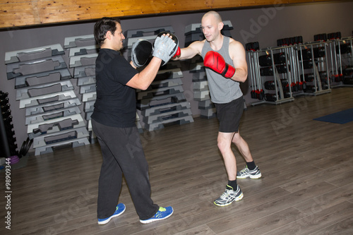 Happy man exercising with trainer at boxe and self defense lesson. Copy space