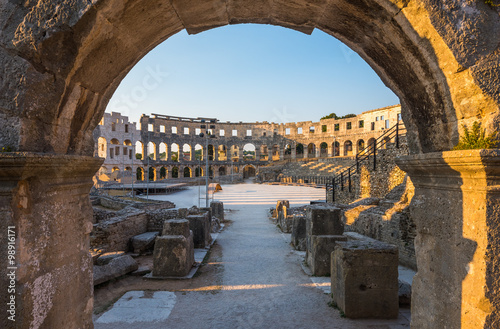 Architecture Details of the Roman Amphitheater Arena Seen through Big Round Arch in Sunny Summer Evening. Famous Travel Destination in Pula, Croatia.