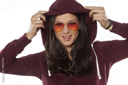 young smiling woman with a hood and sunglasses