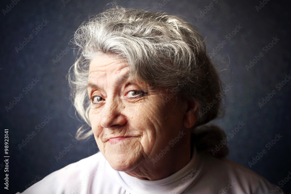 Cunning and thinking granny portrait on a blue background