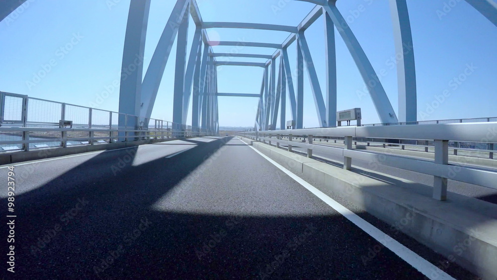 Driver's POV through the highway bridges in central Tokyo on a sunny blue day.
