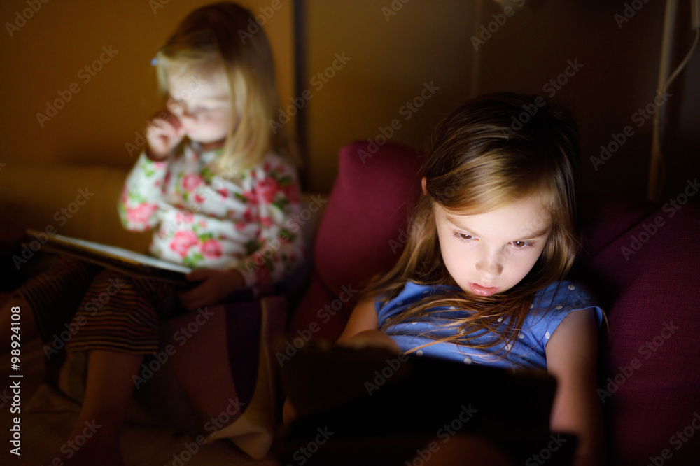 Two little sisters using digital tablet computer Two little sisters using digital tablet computer
