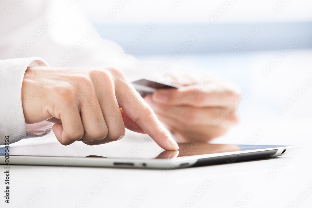 Man holding tablet pc and credit card indoor. Shopping Online
