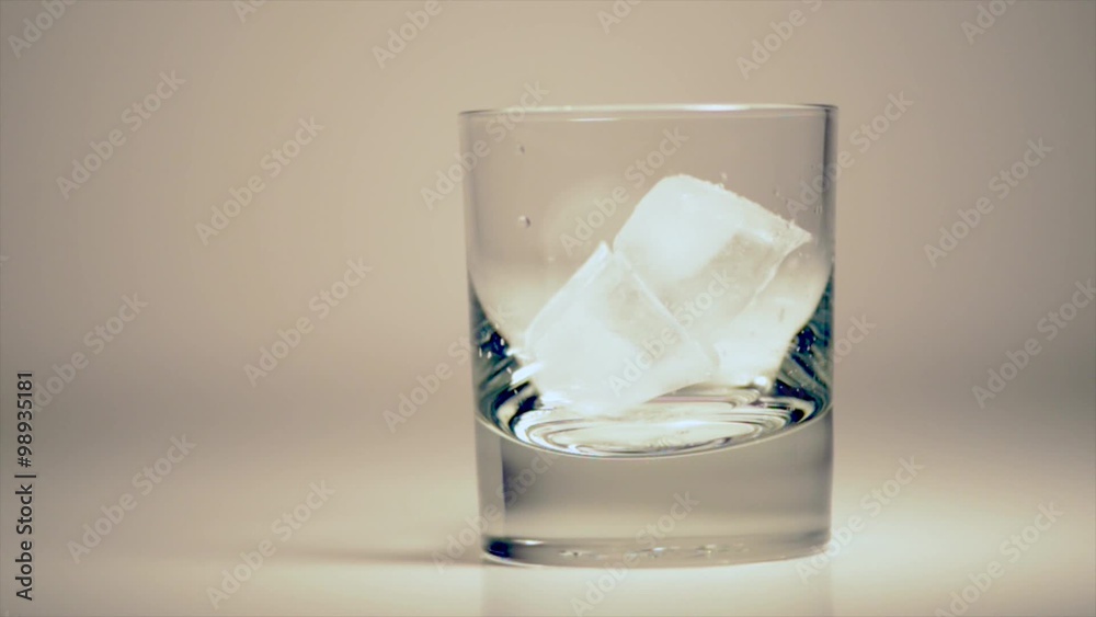 Pouring Double Whiskey Drink Over Ice Cubes 