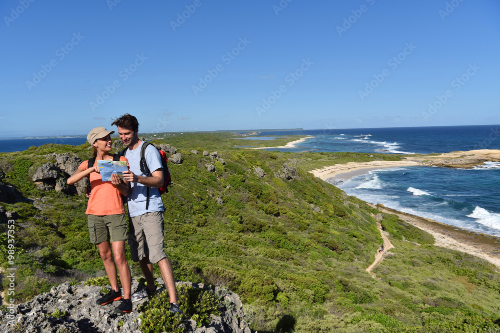 Couple of hikers looking at map and scenery