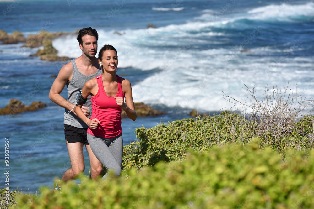 Couple of joggers running by the sea Couple of joggers running by the sea