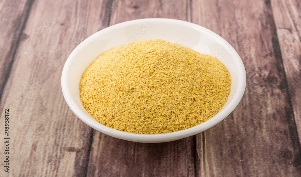 Dried bakers yeast in white bowl over wooden background Dried bakers yeast in white bowl over wooden background