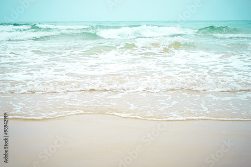 Sea waves flowing into white beach