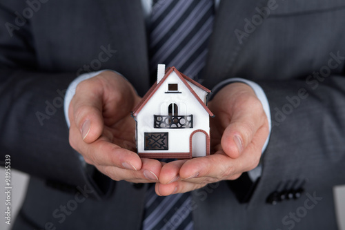 Business man holding house model