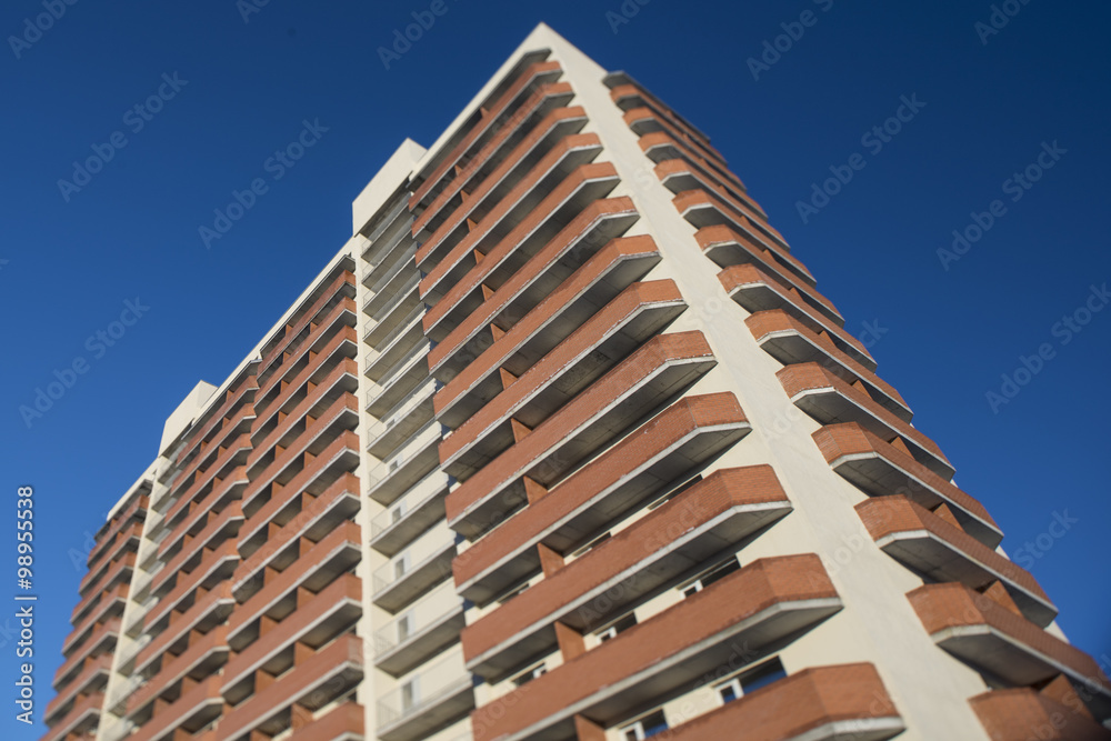high residential building on a background of blue sky with tilt-shift effect
