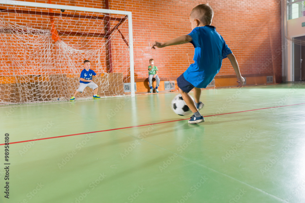 Young boys playing soccer taking aim at the goal