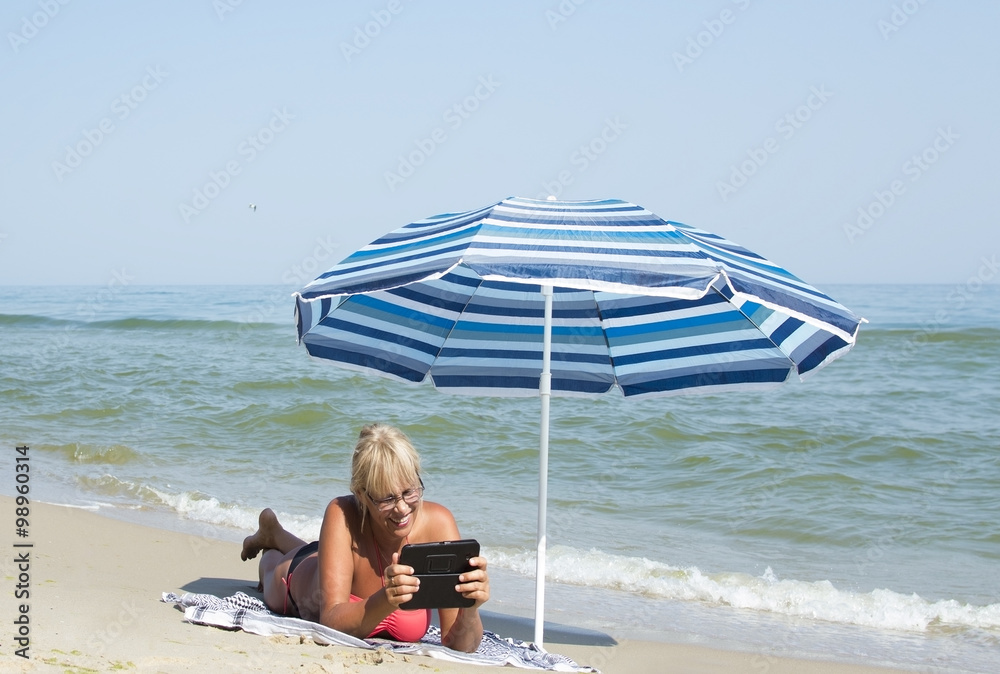 woman and an electronic tablet to the sea