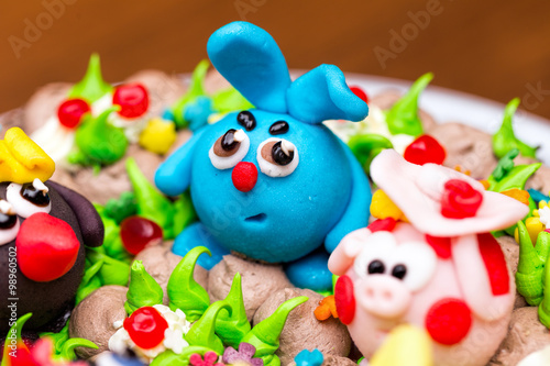 Celebration colorful cake decorated with fruit, chocolate and figures of animals for kids party © ArtEvent ET