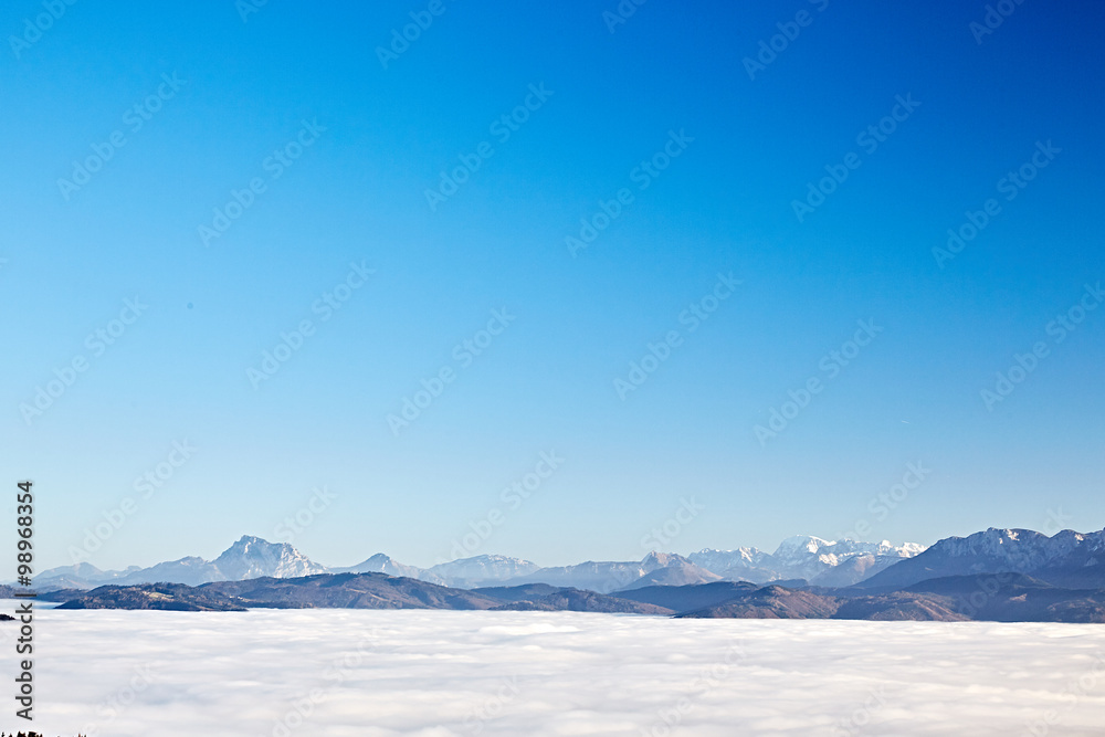 Clear blue sky over the mountains and clouds in the valley Clear blue sky over the mountains and clouds in the valley