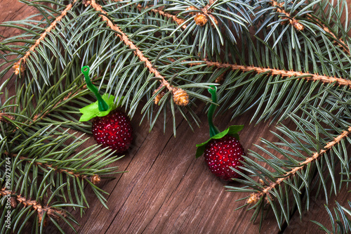 Christmas tree branch and berries on a wooden table or board for