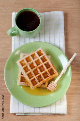 Traditional belgium soft fresh waffles with a honey