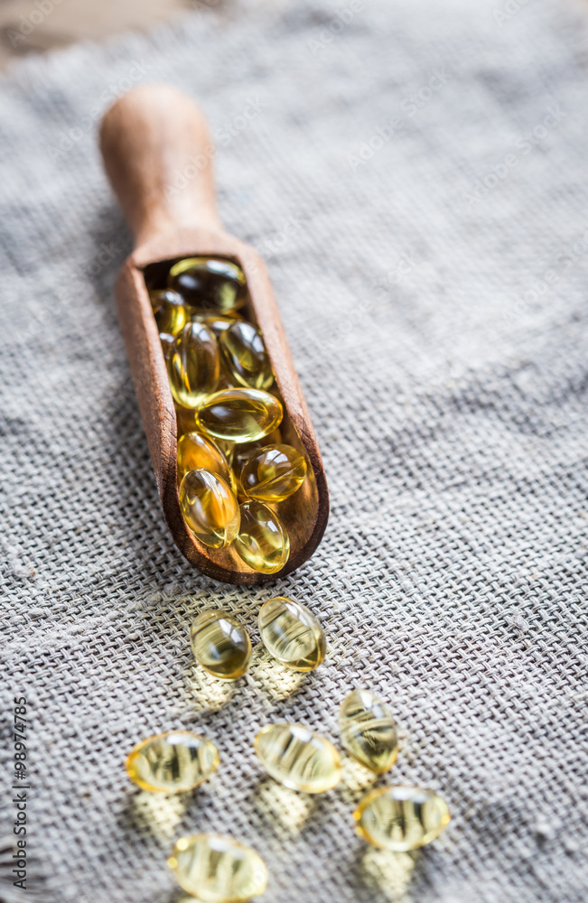 Omega-3 capsules in the wooden scoop Omega-3 capsules in the wooden scoop
