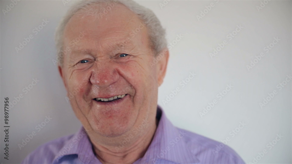 The old man smiles at the camera The old man smiles at the camera