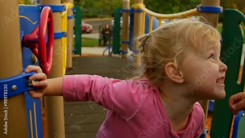 Cute little girl smiles at her friend on the playground 