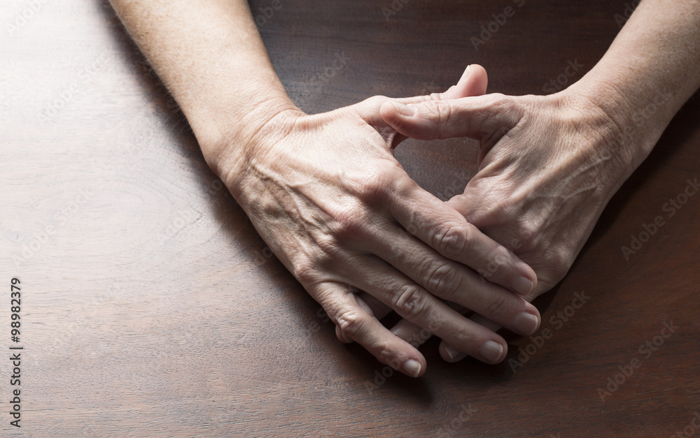 Fototapeta premium talking hands concept - female hands touching together for confusion or embarrassment on wooden table,studio shot