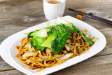 Chinese spicy noodle and vegetable dish in plate setting ready t