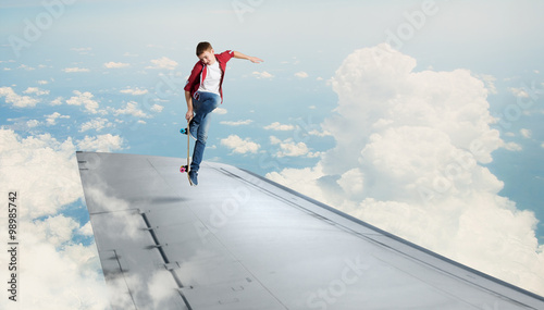 Boy riding skateboard on wing