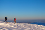 Two skiers walking mountains
