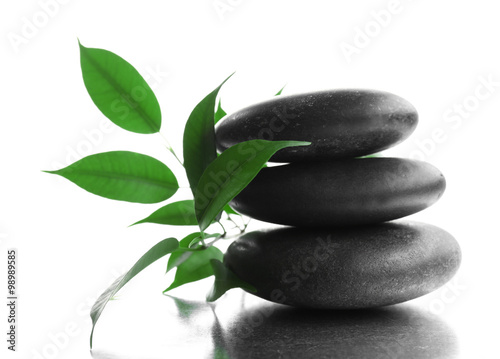 Stack of stones and a green flower  isolated on white. Spa relaxation concept