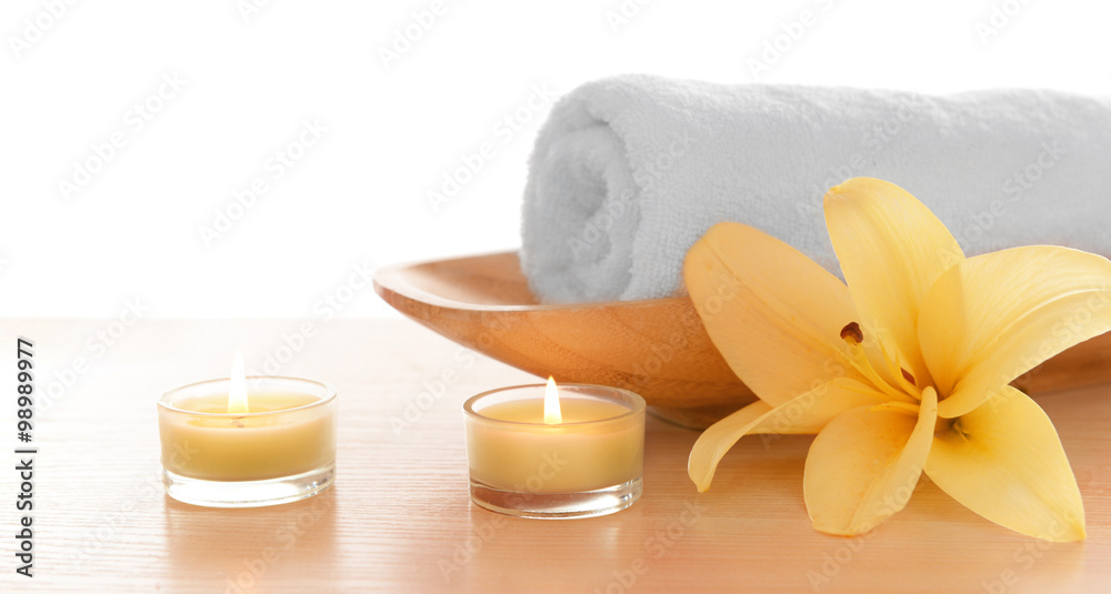 Spa towel with candles and lily, isolated on white Spa towel with candles and lily, isolated on white